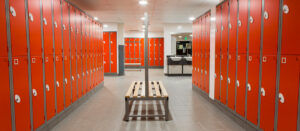 Bright red lockers with benches for changing rooms from Garran Lockers