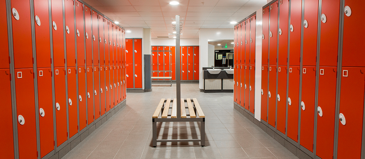 Bright red lockers with benches for changing rooms from Garran Lockers